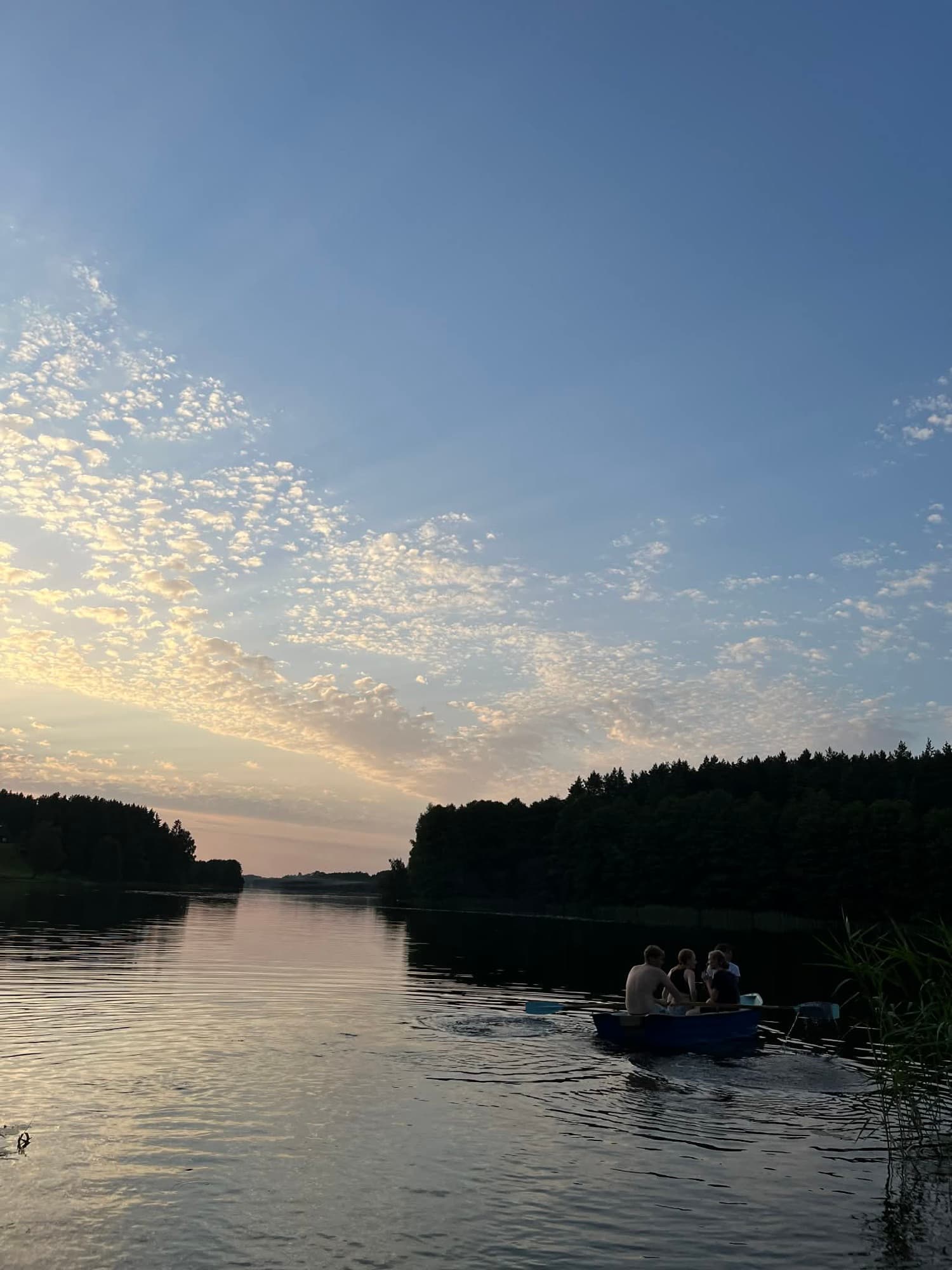 Guests rowing on Lake Ilgis at sunset
